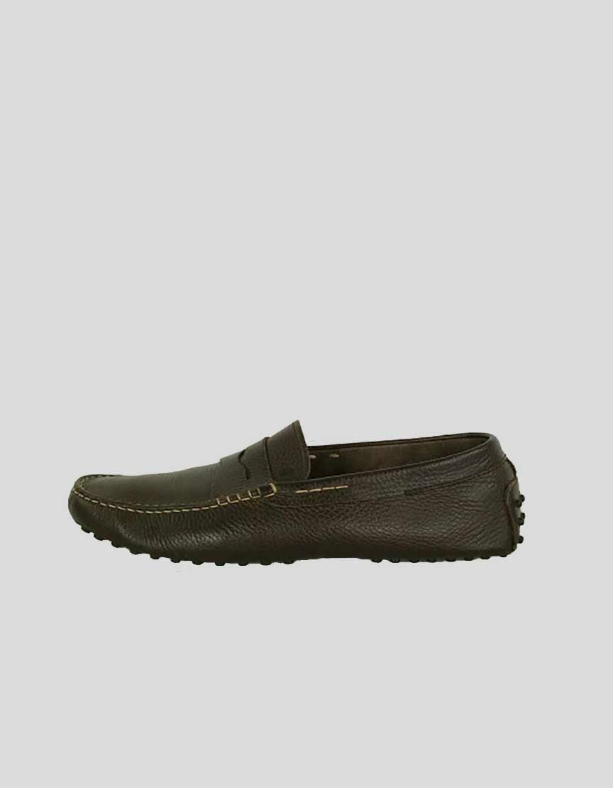 A dark brown pebble leather TOD's penny driving shoe with cream stitching and an extended rubber sole.