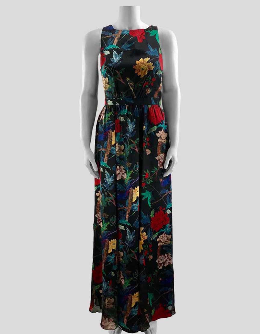 A long T-back, sleeveless black dress with a multicolor flower print. It features a round neck, a black exposed side zipper, and a see-through chiffon design at the hem.