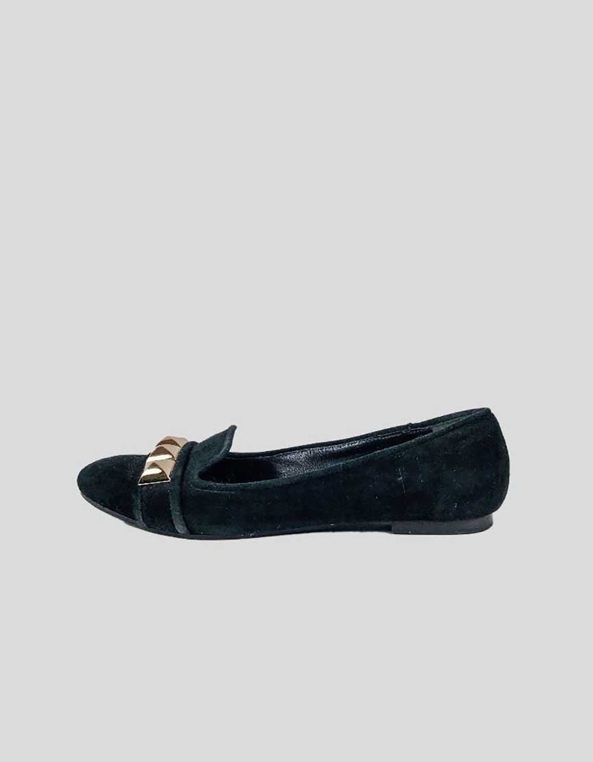 Black suede flats with gold-tone stud design at the toe and tonal stitching, displayed against a white background.