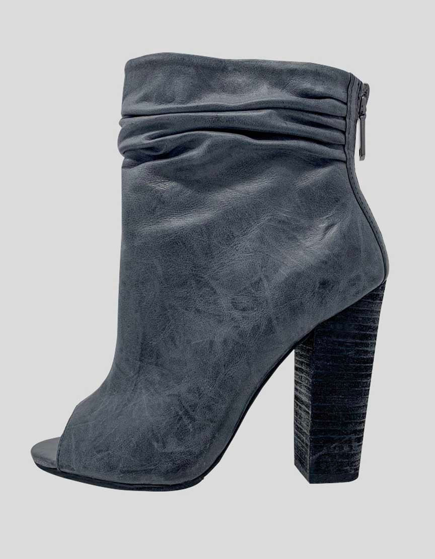 A pair of grey distressed leather peep toe booties with a ruching detail at the ankle and a wooden stacked heel.