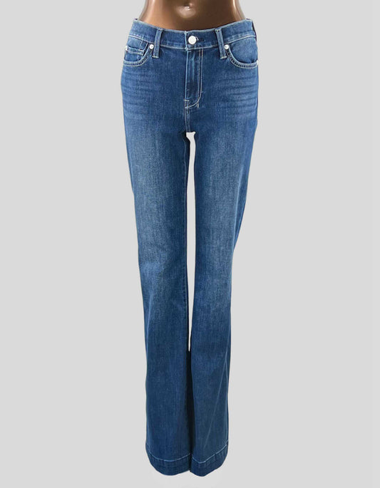 A pair of 7 FOR ALL MANKIND wide leg jeans with a subtle flare, displayed on a mannequin. The jeans are light blue in color, showing no visible signs of wear.