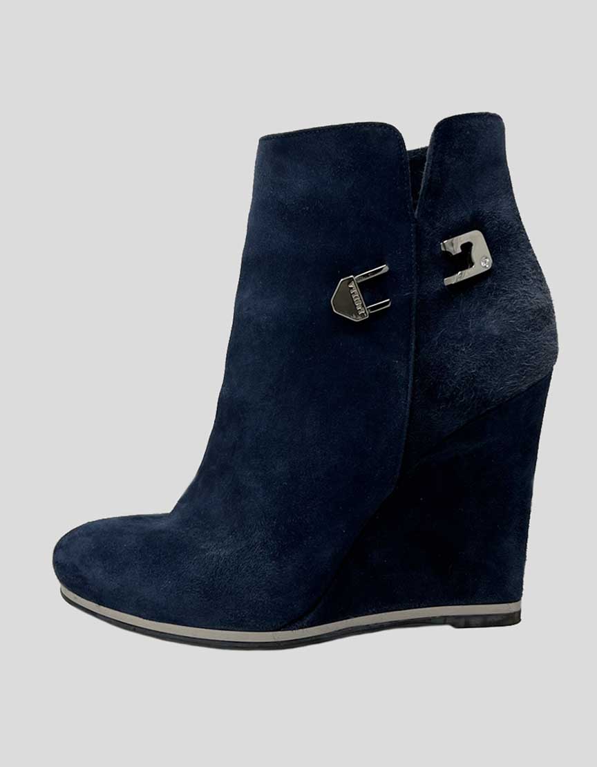 A blue suede ankle boot with a wedge heel and side zip closure. Features silver-tone hardware and a round toe.
