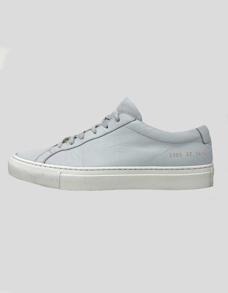 A pair of gray leather low-top sneakers with lace-up closure.