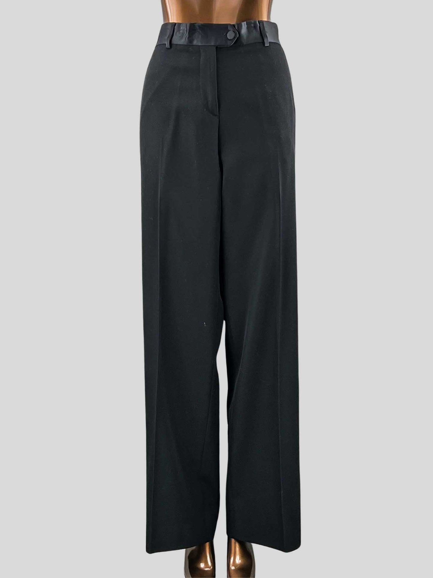 Black pleated tuxedo wool trousers with a satin waistband and side pockets, displayed on a mannequin.