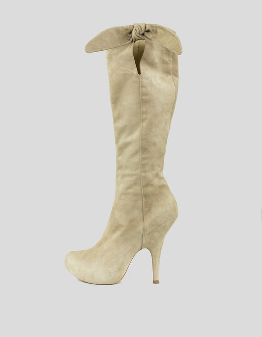 Tan suede platform knee-hi boots with a tie bow design at the top, displayed against a white background.