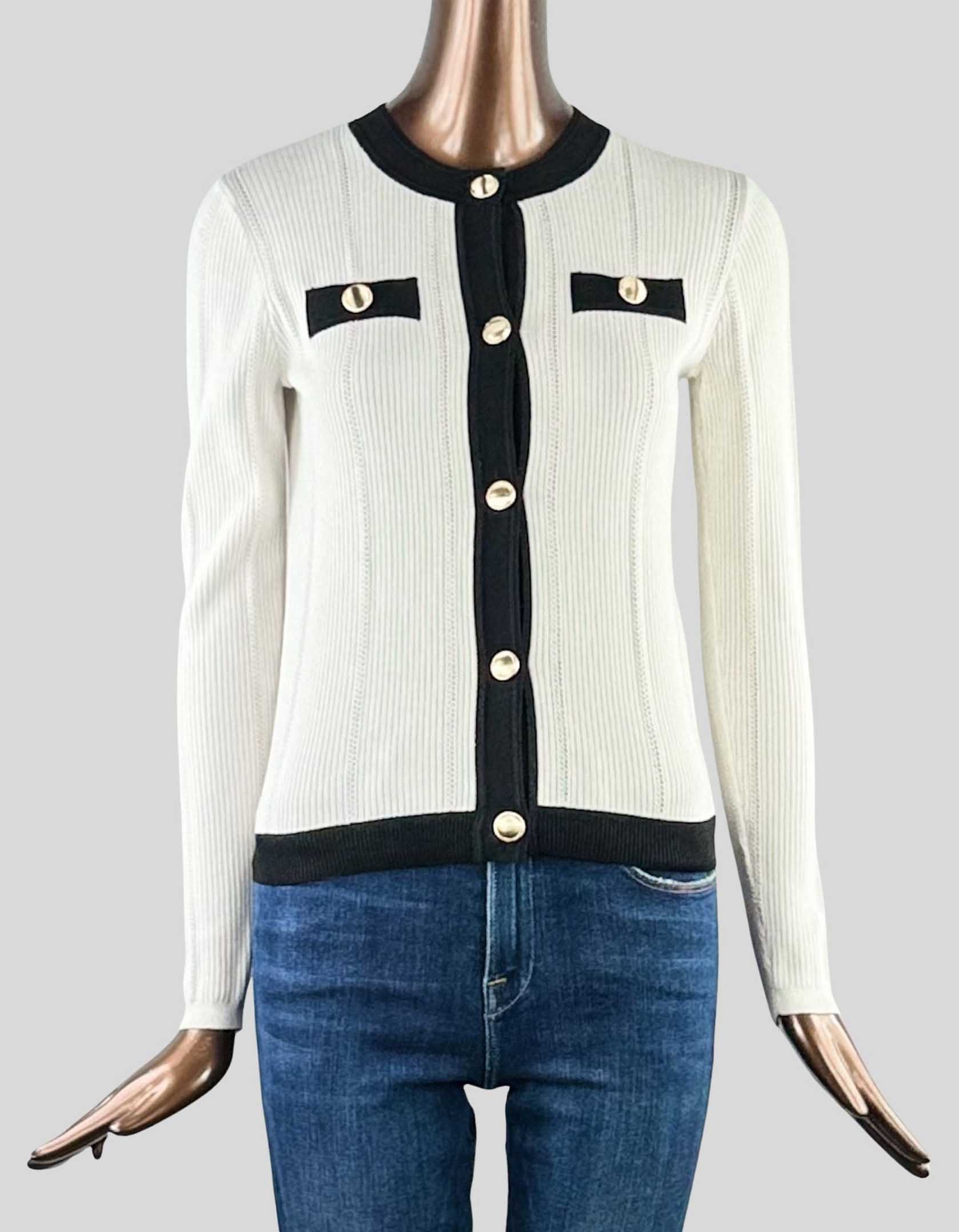 ANN TAYLOR Textured Sweater Jacket in white with black details. Crew neck. Front button closures. Gold-tone buttons throughout. Long sleeves. Faux front chest-welt pockets.