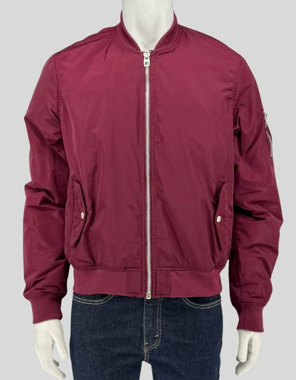 Authentic screen-worn Point Zero burgundy nylon bomber jacket featuring silver zipper closures, side pockets, sleeve utility pocket, and ribbed cuffs and hem. 