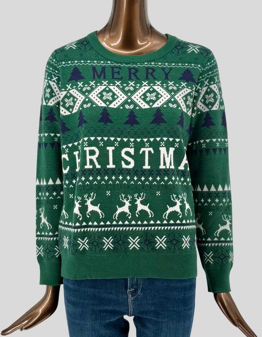 Authentic screen-worn green holiday sweater featuring "MERRY CHRISTMAS" text with classic Fair Isle pattern including reindeer, snowflakes, and Christmas trees in white and navy. Crew neck with ribbed trim.