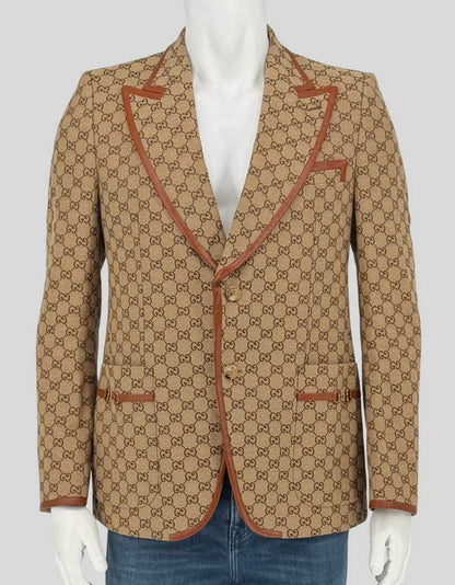 Authentic screen-worn Gucci GG canvas blazer featuring signature beige/ebony monogram pattern with contrasting tan leather trim. Single-breasted design with horn-effect buttons 