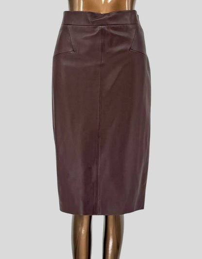 Authentic REISS burgundy leather pencil skirt featuring high-rise waistband, center front seam detail, side pockets, and back zipper closure with vent. Fully lined. 