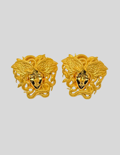 VERSACE Gold-Tone Tribute Medusa Stud Earrings. Iconic Medusa head design with intricate serpentine detailing. Three-dimensional sculptural effect. Hypoallergenic materials.