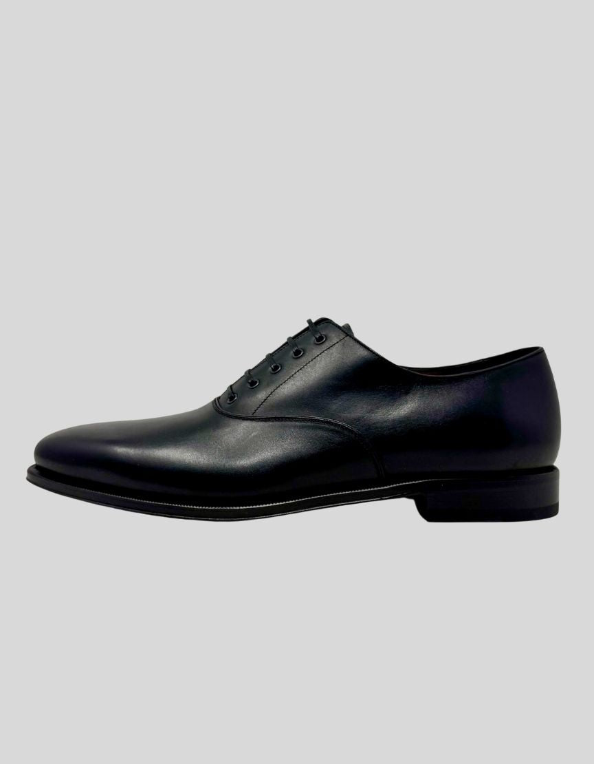 SALVATORE FERRAGAMO Classic Oxford Dress Shoes in Black Leather. Classic plain-toe oxford silhouette Five-eyelet lace-up closure. Premium Italian calf leather upper. Leather lining and insole. Leather sole with rubber heel tap.