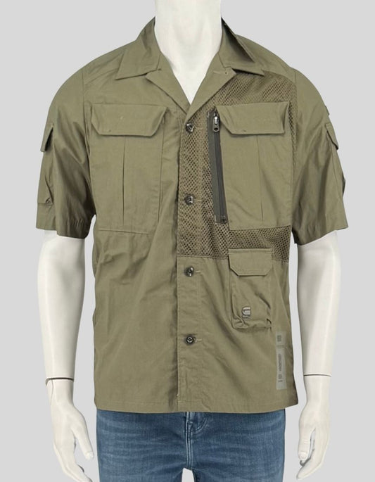 G-STAR RAW sage green utility overshirt featuring tactical-inspired design with mesh ventilation panels on chest and back. Multiple functional pockets include zippered chest pocket, button-flap cargo pockets, and internal storage. Short-sleeve