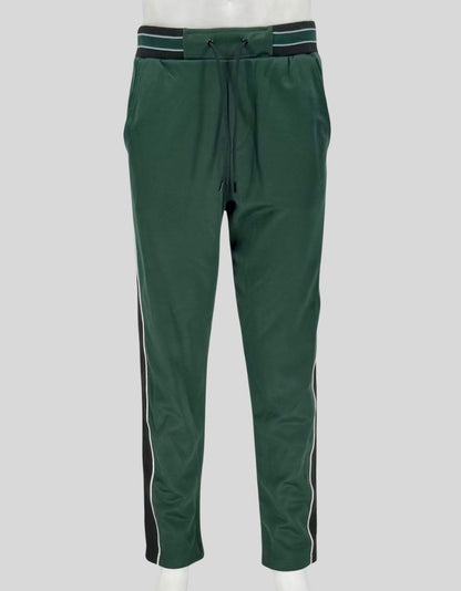 THE KOOPLES forest green track pants featuring contrast side stripes in black and white with piping detail. Elastic waistband, adjustable drawstring, side pockets, and tapered leg.