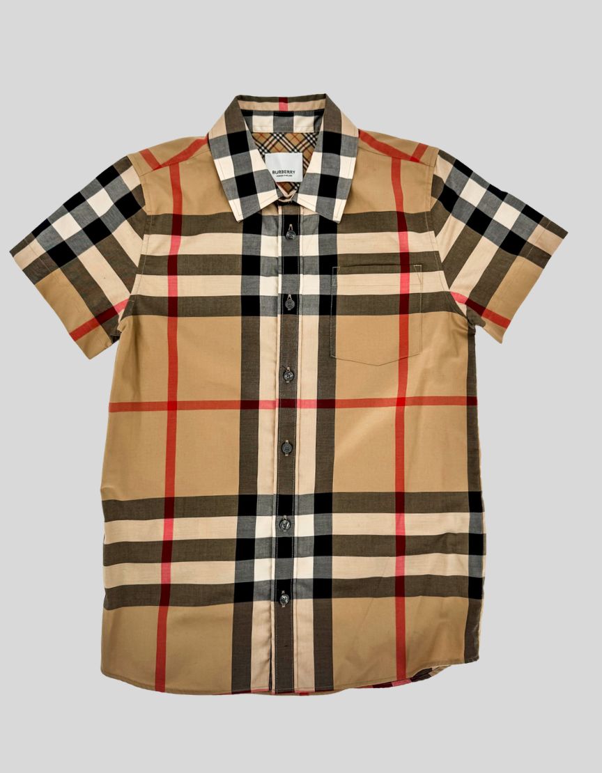 BURBERRY classic check short-sleeve shirt in archive beige with red, black, and white accents. Premium cotton poplin with pointed collar, chest patch pocket, and curved hem. Full button-front closure with mother-of-pearl buttons. Nova check lining inside collar and placket.