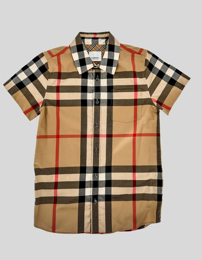 BURBERRY classic check short-sleeve shirt in archive beige with red, black, and white accents. Premium cotton poplin with pointed collar, chest patch pocket, and curved hem. Full button-front closure with mother-of-pearl buttons. Nova check lining inside collar and placket.