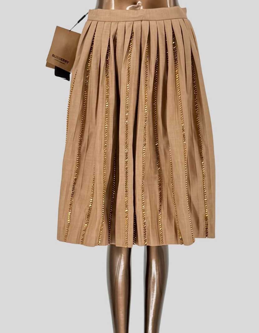 BURBERRY runway pleated midi skirt featuring vertical rows of crystals woven through each pleat creating dazzling light-catching detail. Luxurious cotton-blend construction in soft camel beige (pale biscuit). High-waisted silhouette with grosgrain waistband. Side zip closure. Fully lined.