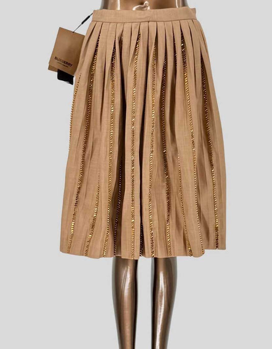 BURBERRY runway pleated midi skirt featuring vertical rows of crystals woven through each pleat creating dazzling light-catching detail. Luxurious cotton-blend construction in soft camel beige (pale biscuit). High-waisted silhouette with grosgrain waistband. Side zip closure. Fully lined.