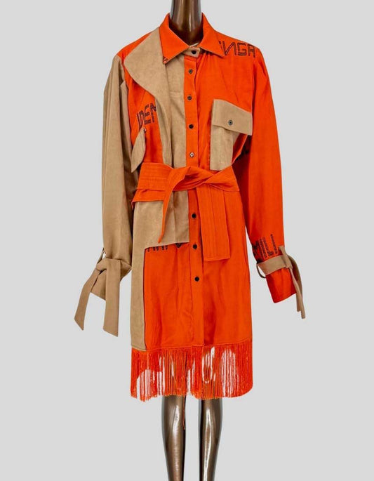 CYNTHIA ABILA statement coat featuring dramatic orange cotton and tan suede colorblock design. Handcrafted by Nigerian artisans with embroidered text detailing. Mixed-media construction combines soft suede panels with vibrant cotton. Long sleeves with tie cuffs. Removable waist belt for versatile styling. 