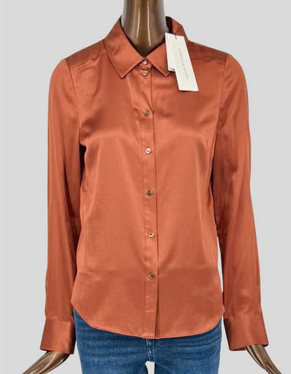 VERONICA BEARD luxurious silk charmeuse blouse in rich burnt orange. Classic tailored silhouette with pointed collar and button-front closure. Long sleeves with button cuffs. Curved hem