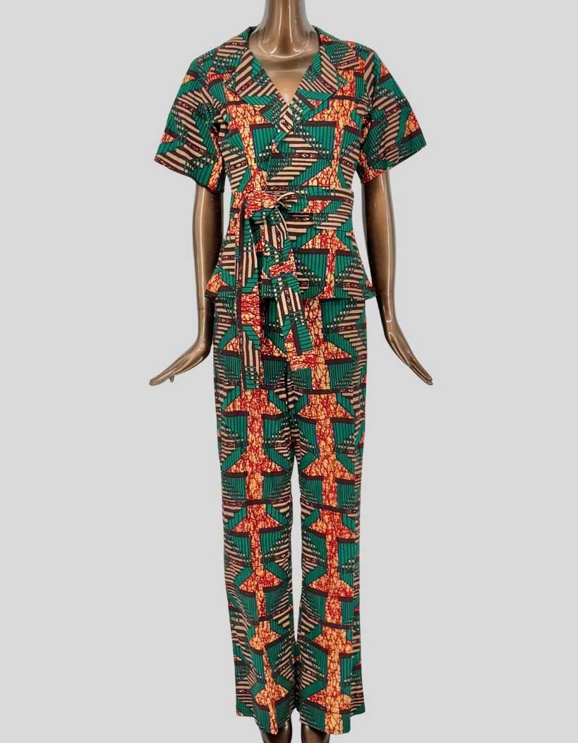 TRIBALBYN bold African print matching set featuring geometric patterns in emerald green, orange, and cream. Short-sleeve jacket with notched lapel collar and self-tie belt. Matching straight-leg pants with comfortable elastic waistband. 