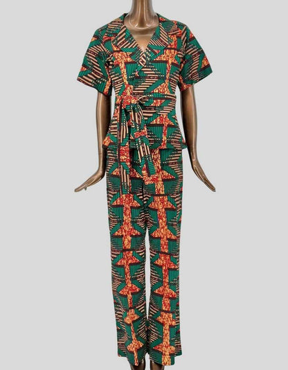 TRIBALBYN bold African print matching set featuring geometric patterns in emerald green, orange, and cream. Short-sleeve jacket with notched lapel collar and self-tie belt. Matching straight-leg pants with comfortable elastic waistband. 