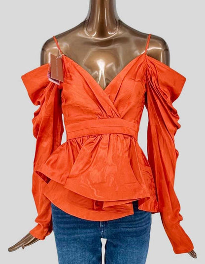 SILVIA TCHERASSI dramatic tangerine orange taffeta top featuring cold-shoulder design with voluminous ruffle sleeves. Wrap-front bodice with empire waistband creates flattering silhouette. Adjustable spaghetti straps and asymmetric peplum hem.