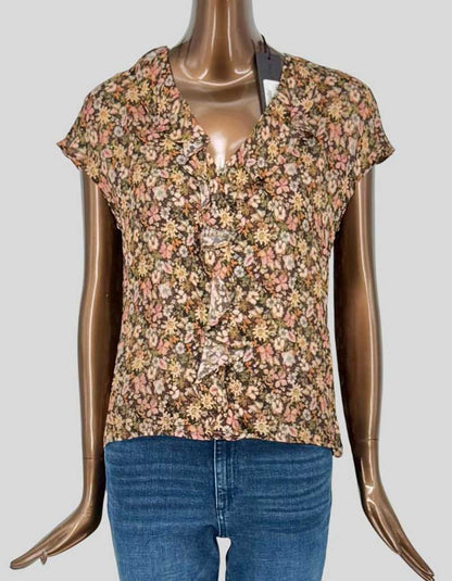 HILTON HOLLIS feminine floral print blouse in rich autumnal tones featuring a V-neckline with cascading ruffle placket. Cap sleeves and relaxed silhouette create effortless elegance. Allover ditsy floral print in shades of pink, cream, and yellow on a deep brown/olive ground. 