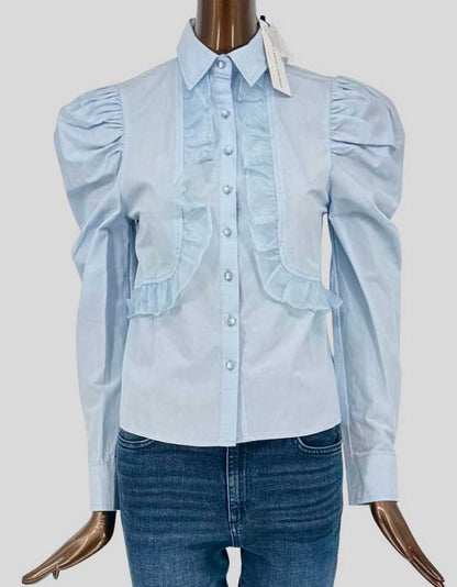 LABELRAIL x OLIVIA &amp; ALICE ruffle front blouse in pale blue features dramatic puff sleeves with gathered shoulders, cascading ruffle bib detail, point collar, and button front closure. 