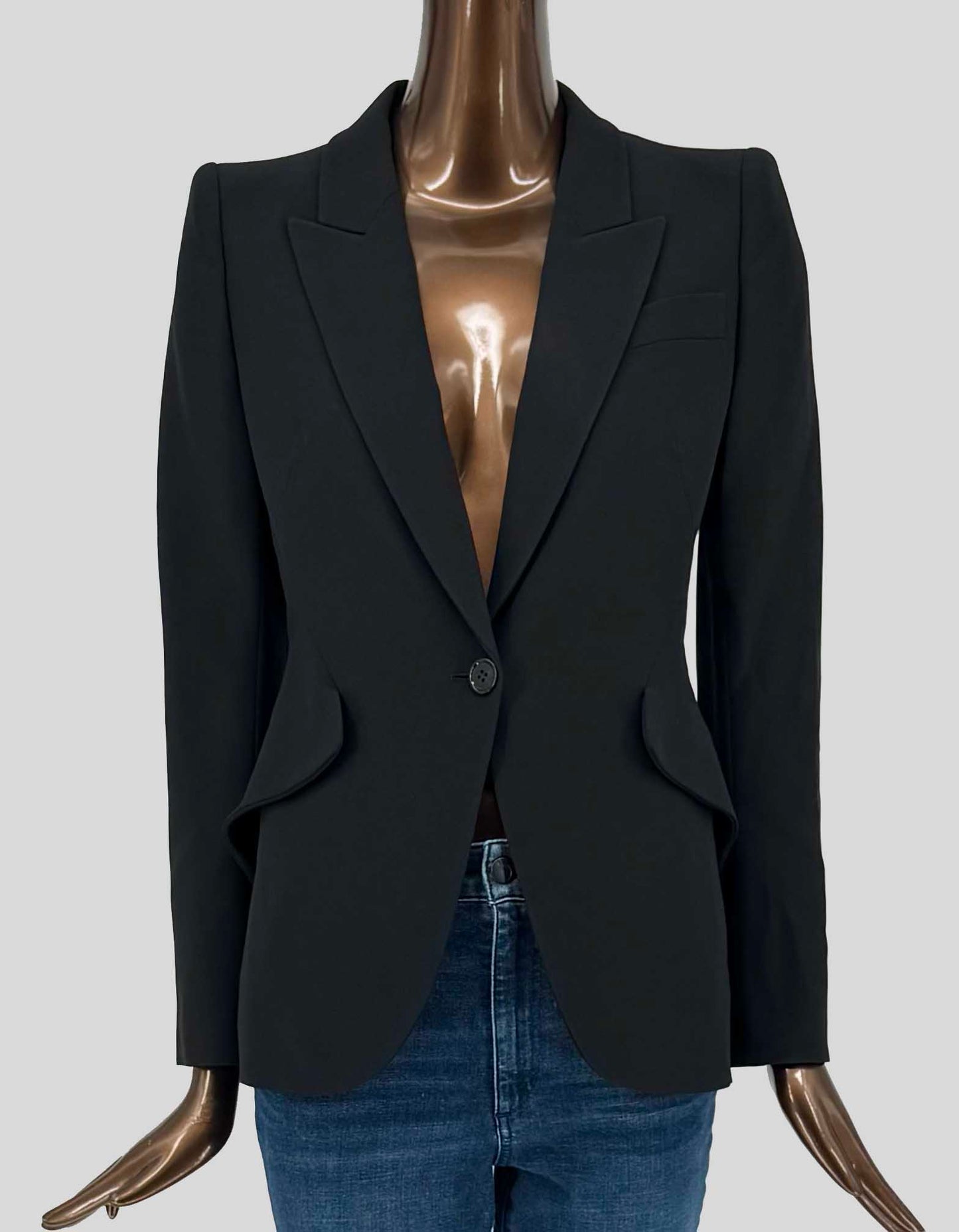 ALEXANDER McQUEEN's impeccably tailored single-button blazer in black features signature peak lapels, structured shoulders, and a nipped waist with curved hem. Welt chest pocket, flap hip pockets. Fully lined.