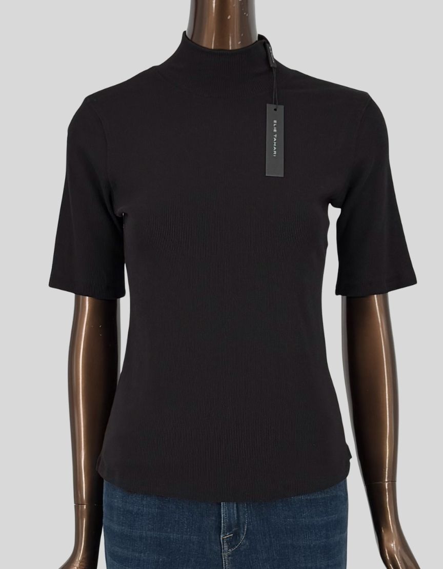 ELIE TAHARI ribbed knit mock neck top in black. Short sleeves with fine ribbed texture throughout. Mock turtleneck. Fitted silhouette. Slip-on styling. Made from soft, stretchy rib knit fabric.