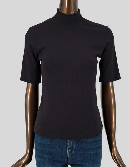 ELIE TAHARI ribbed knit mock neck top in black. Short sleeves with fine ribbed texture throughout. Mock turtleneck. Fitted silhouette. Slip-on styling. Made from soft, stretchy rib knit fabric.
