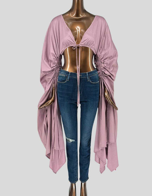 CULT GAIA Priscilla gathered top in ethereal elderberry mauve. Dramatic cropped design with deep V-neck and tie-front closure. Long sleeves feature extensive gathered ruching along sides creating voluminous, billowy effect. Handkerchief asymmetric hem adds flowing movement.