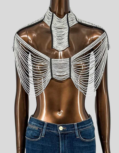 ODAOMO handcrafted Maasai glass bead chain crop top in white. Stunning statement piece featuring elaborate hand-strung glass beads creating dramatic chainmail-effect draping. High collar with black leather trim and silver stud details. Layered beaded chains cascade from shoulders creating architectural coverage across chest and back.